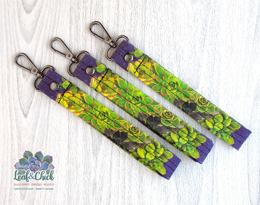 three purple succulent key fobs displayed on an angle