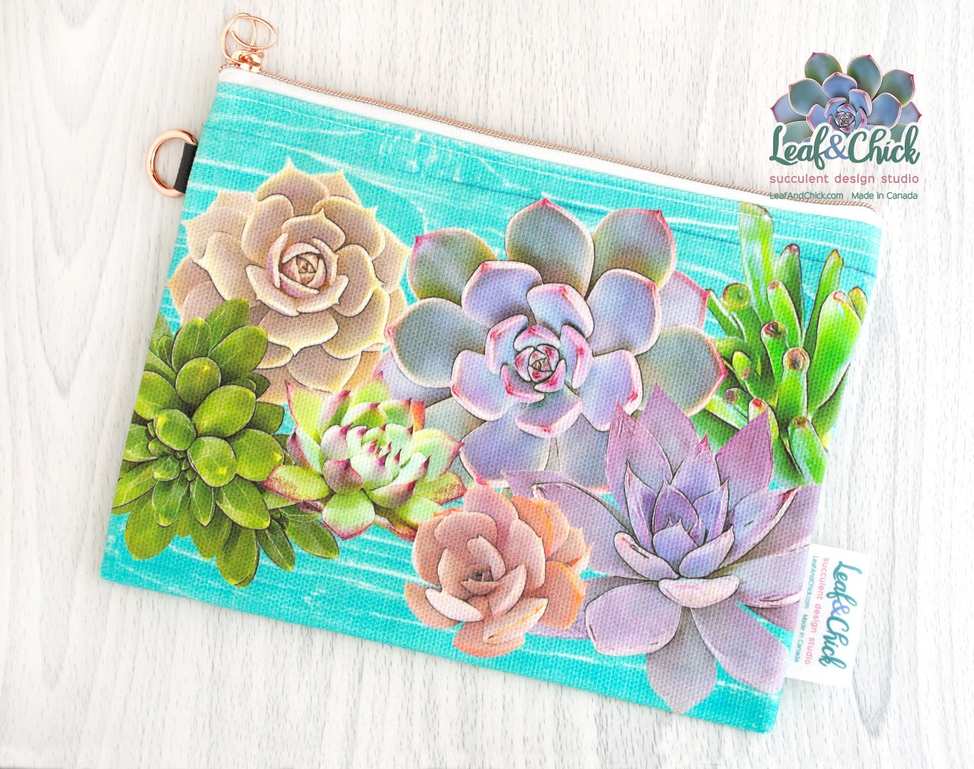 an aqua light teal zip pouch with colourful succulent art