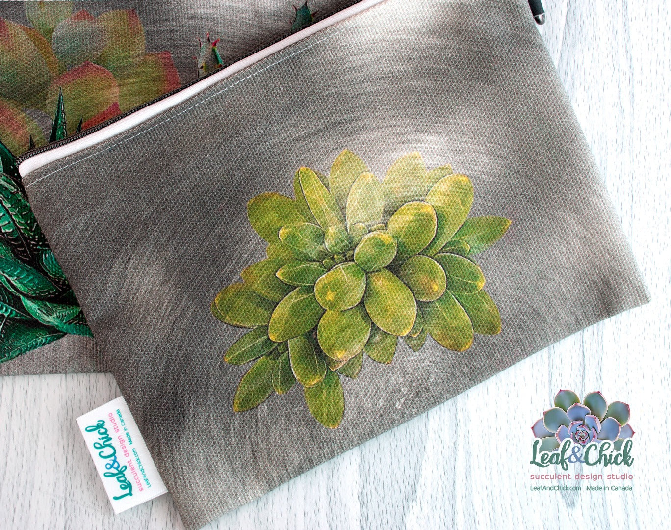 close up of faded back succulent art on the back of the grey zipper pouch