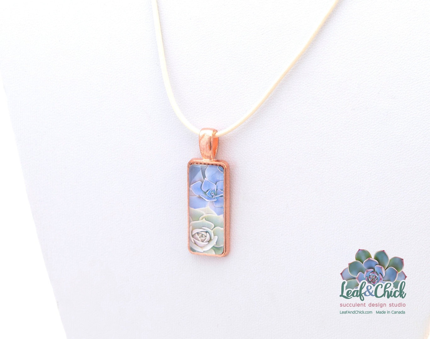 close up rose gold succulent pendant on ivory leather cord